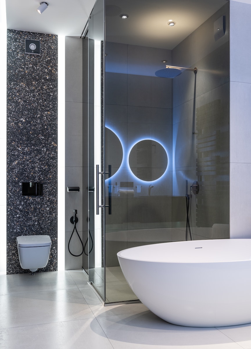 Interior de cuarto de baño espacioso moderno con lámparas brillantes